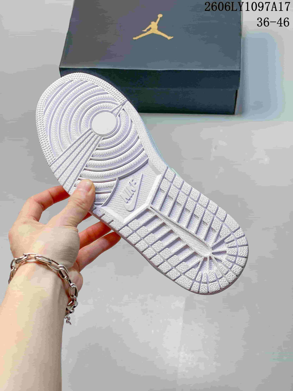 Underside of a white sneaker showing its patterned outsole