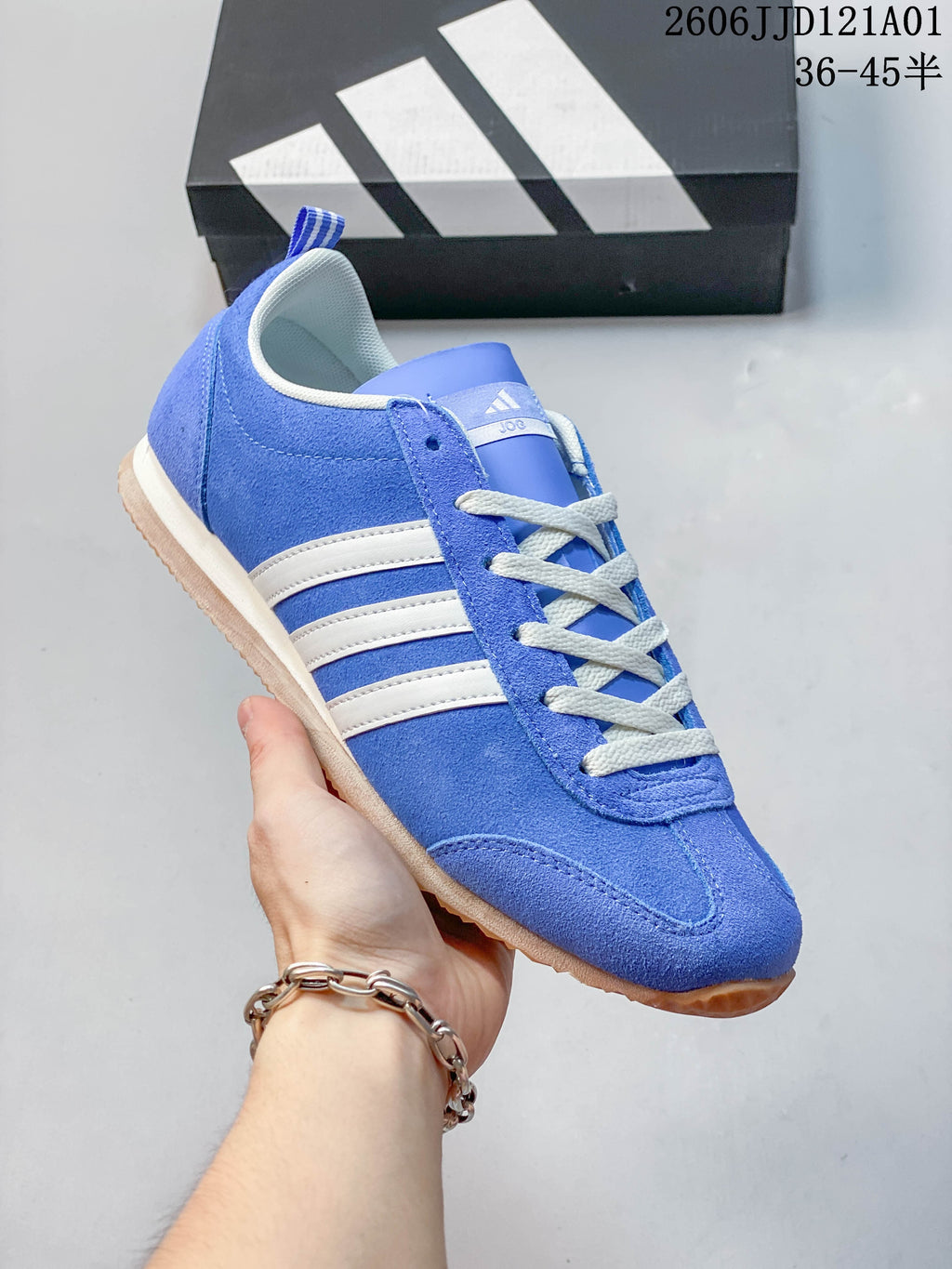 Side view of a blue adidas VS JOG 2.0 sneaker with white stripes.