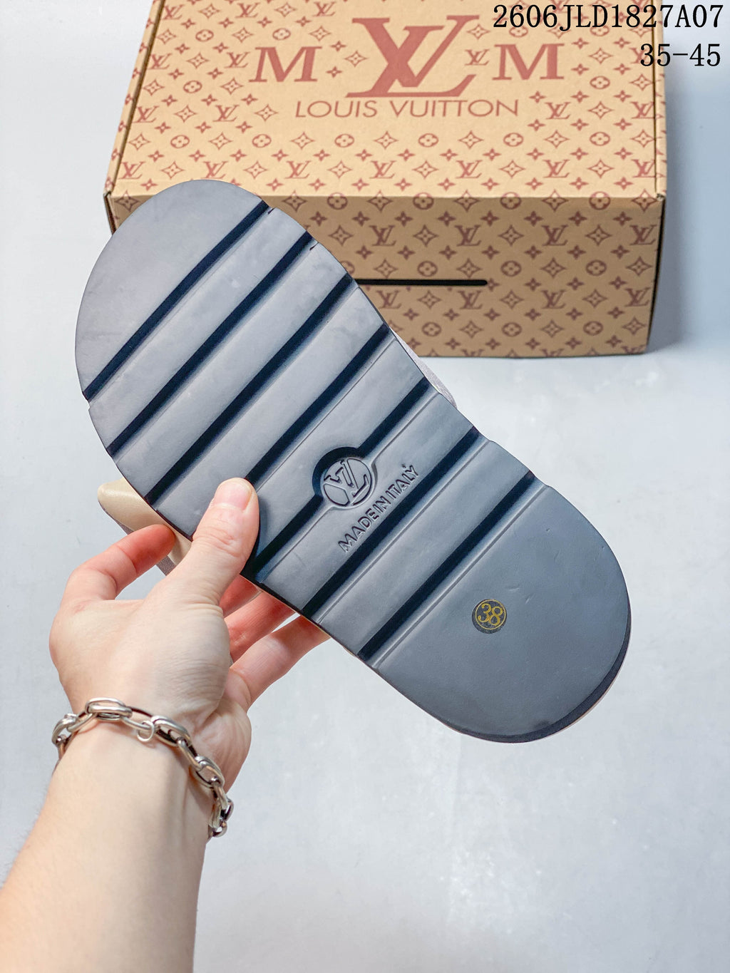 Underside of a slide sandal showing a ridged outsole and a size mark of 38