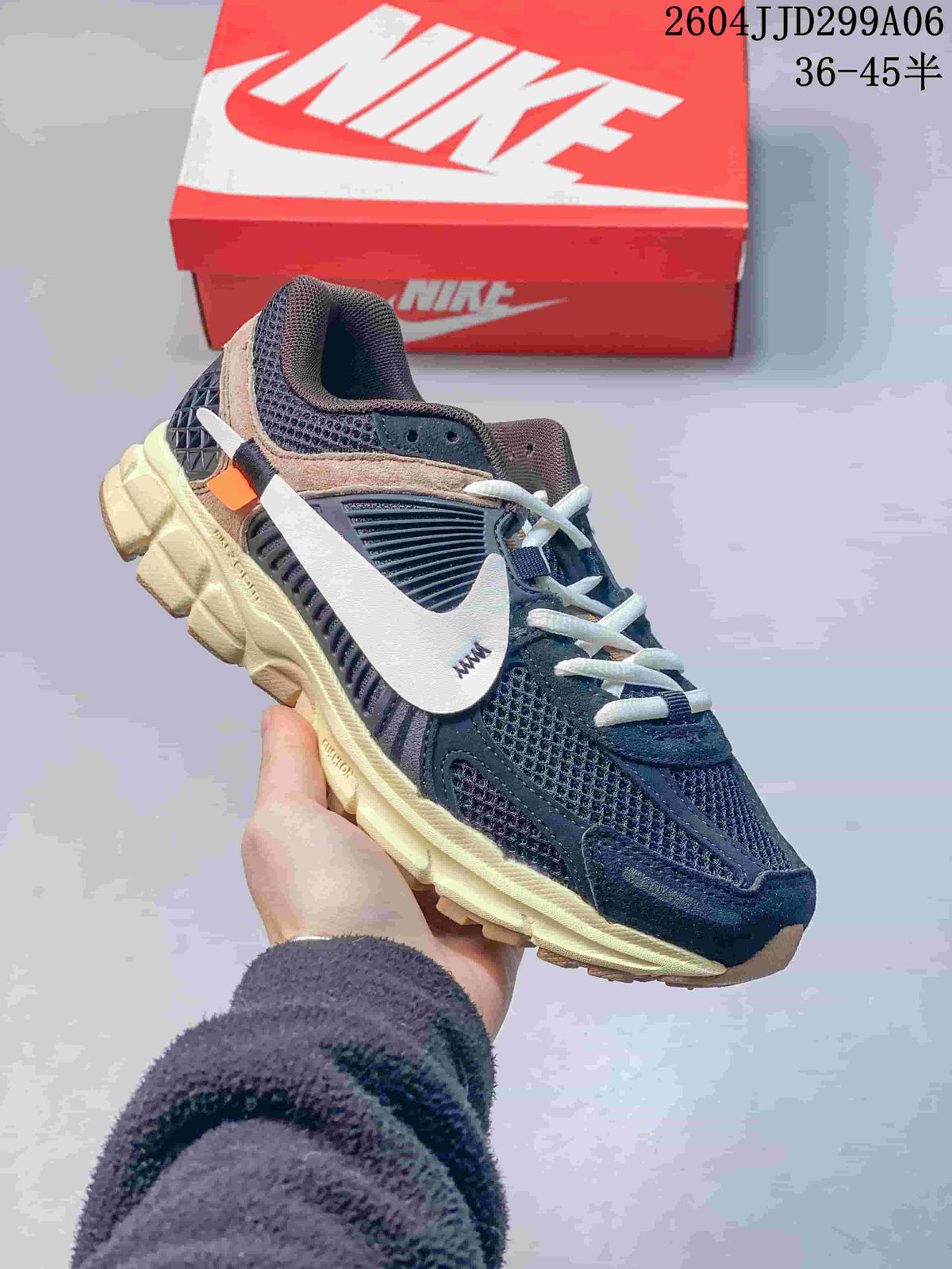 Side view of a dark navy Nike Zoom Vomero 5 sneaker with a white swoosh and pale-toned sole.