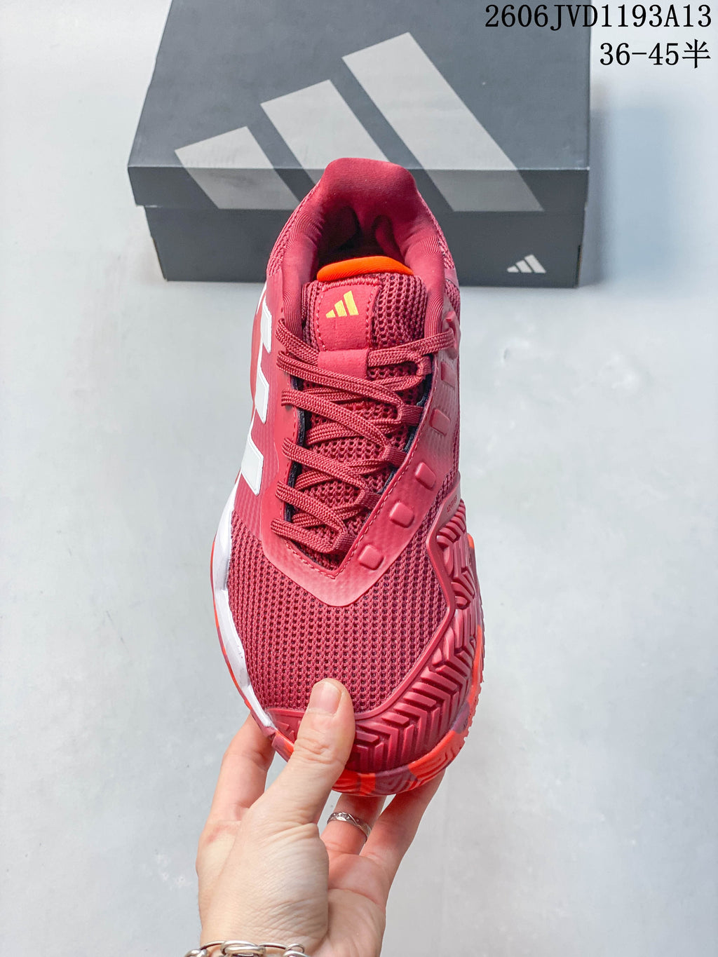 Top view of the red tennis shoe with lace-up closure and mesh toe.
