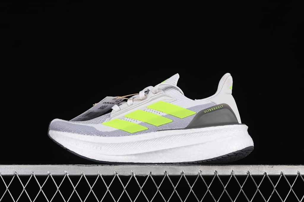 Side view of gray and white Adidas Ultraboost 5X shoes with bright lime accents.