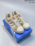 Pair of beige and white Adidas Superstar low-top sneakers shown on a blue shoebox