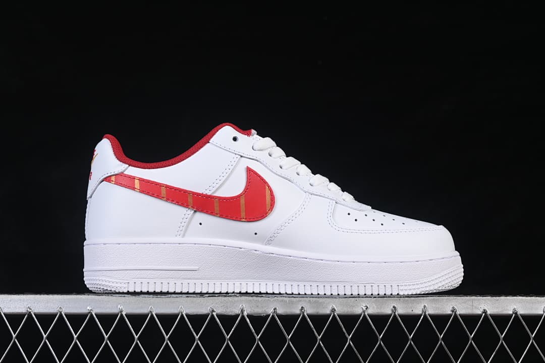 Side view of a white low-top sneaker with a red and gold striped side Swoosh.