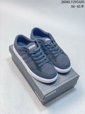 Pair of dark gray Adidas low-top sneakers with white soles, shown on a shoe box