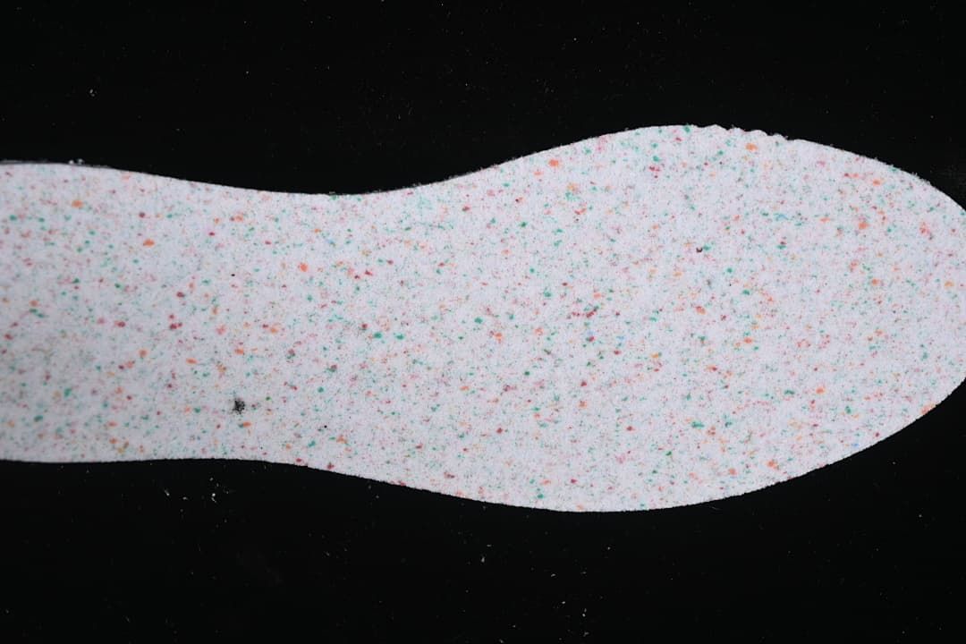 Close-up of a light-colored shoe insole with multicolor speckles.