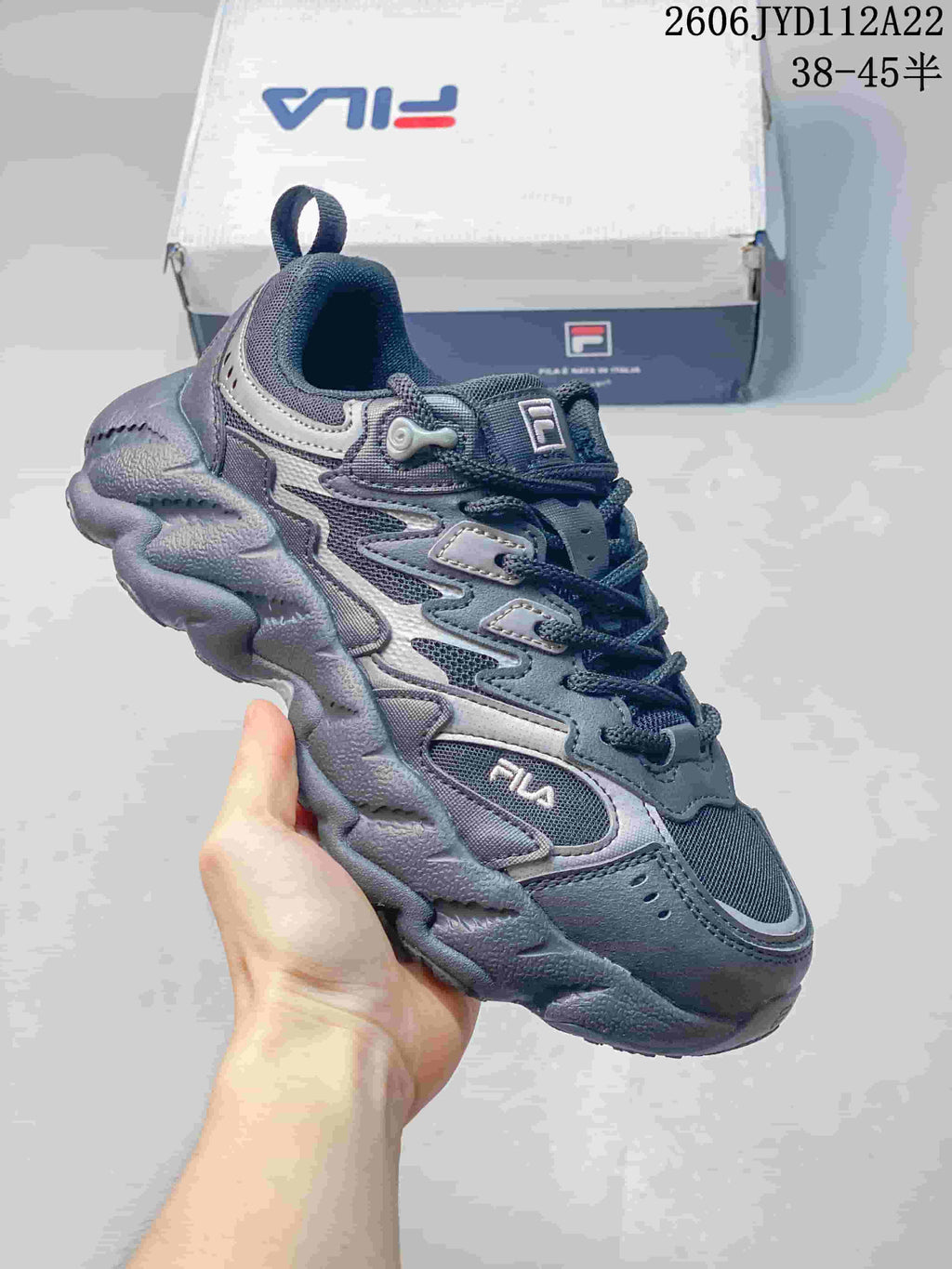 Angled view of a gray FILA sneaker with layered panels and a sculpted sole