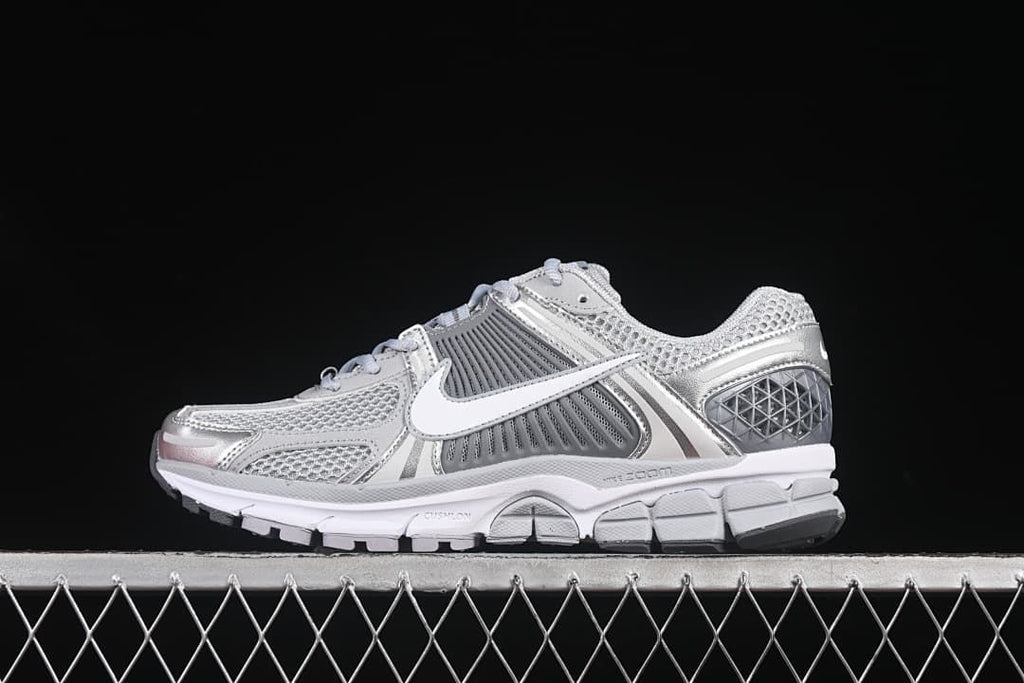 Side view of a silver and grey Nike Zoom Vomero 5 SP sneaker