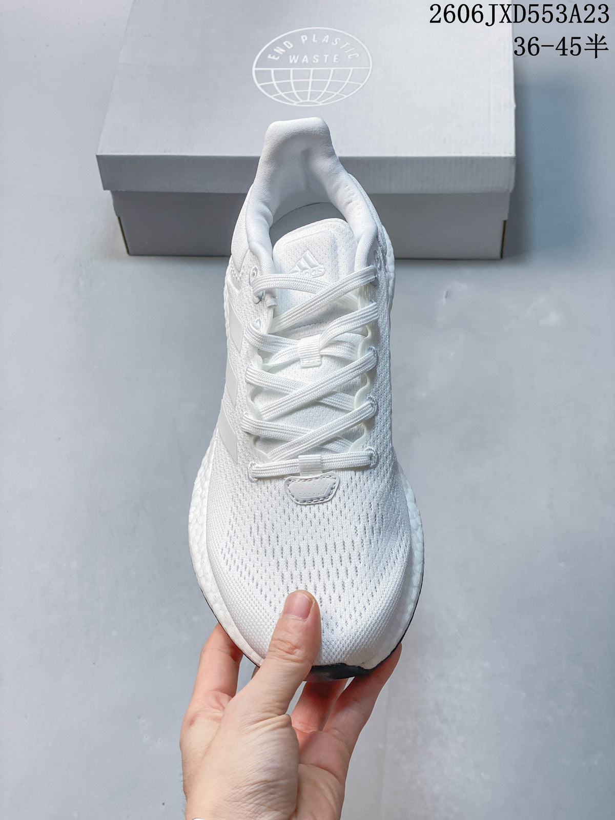 Front view of a white Adidas PureBoost 21 shoe with lace-up fastening