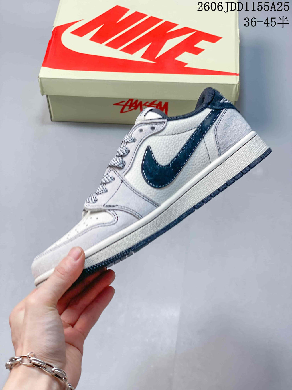 Side view of the white and navy low-top sneaker with contrasting side panel