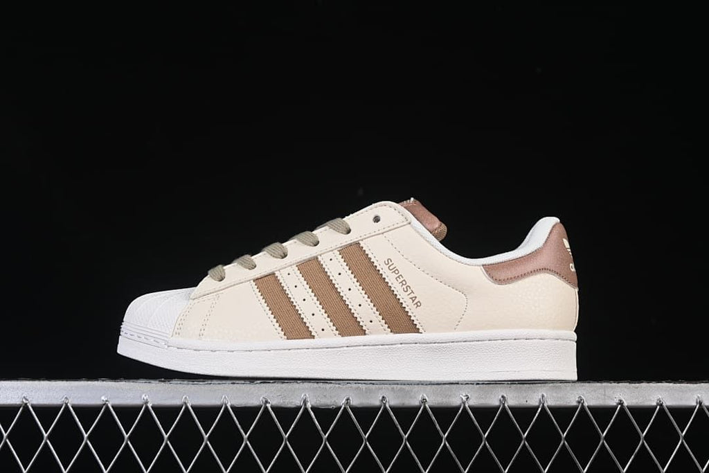 Side view of the cream and brown sneaker against a black background.
