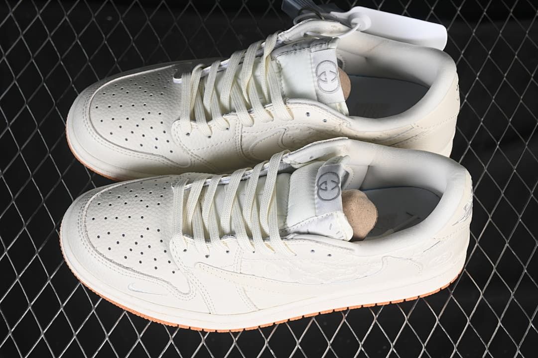 Overhead view of a pair of off-white low-top sneakers with perforated toes and lace-up fronts