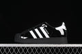 Side view of a black Adidas Superstar II sneaker with white stripes and heel detail