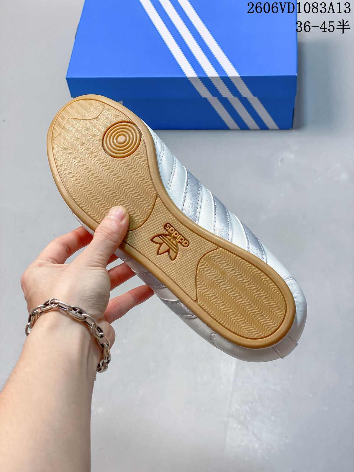 Gum-colored outsole with patterned tread on a white sneaker.