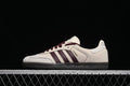 Side profile of a cream adidas Samba OG sneaker with burgundy stripes and laces and a dark outsole.