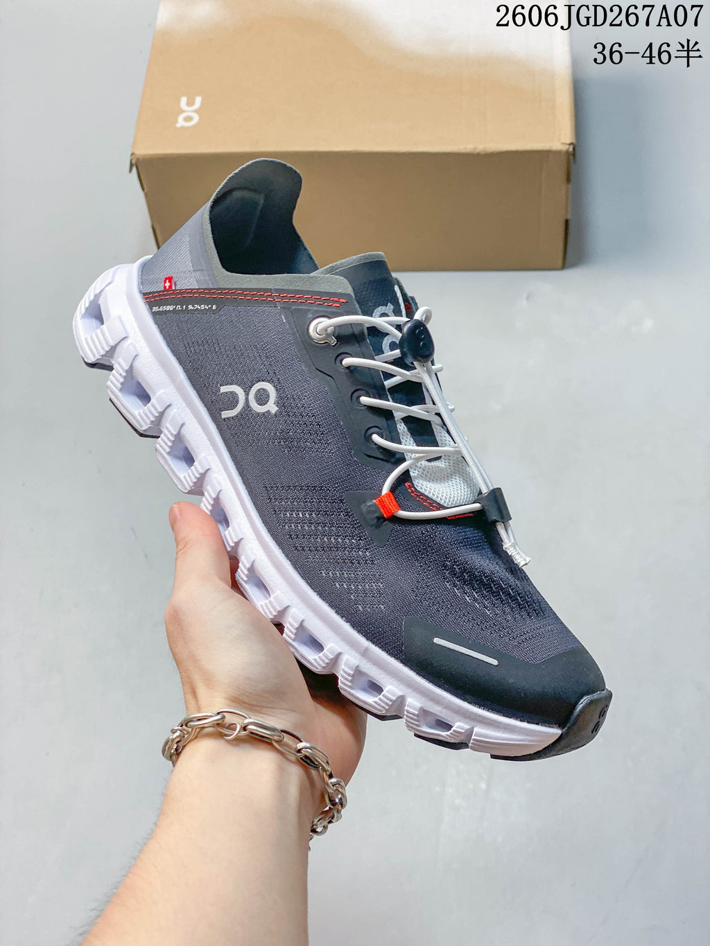 Angled side view showing the gray upper, white segmented outsole, and red accent stitching.
