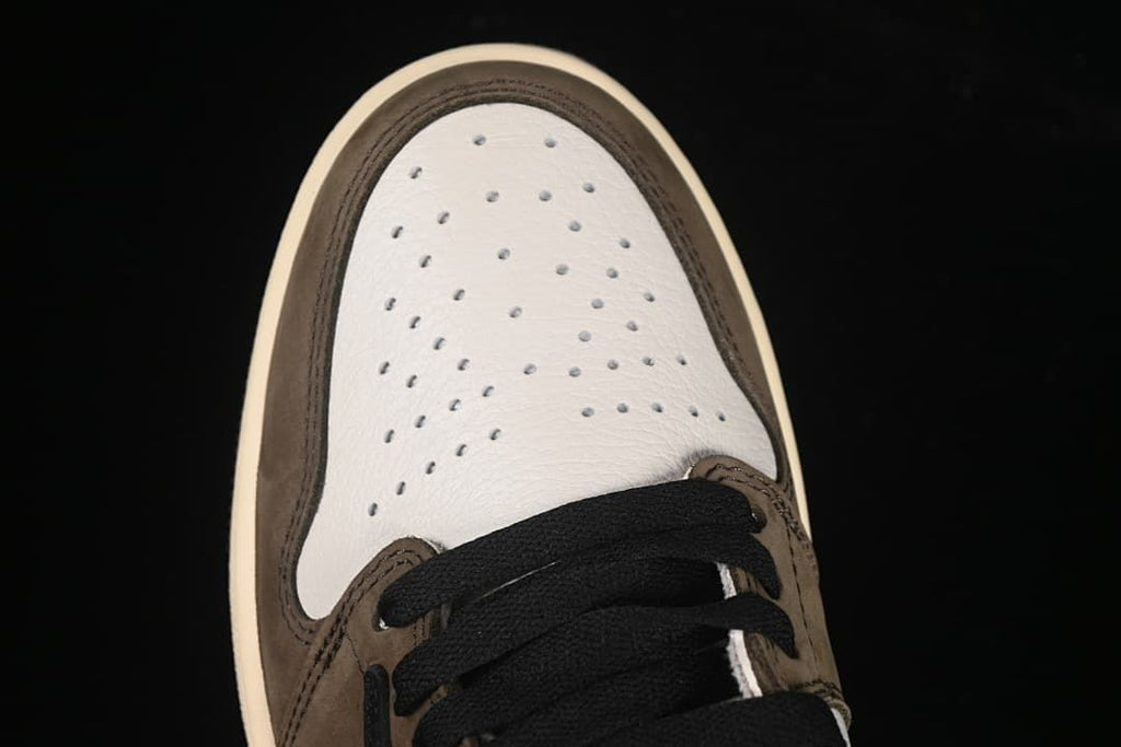 Top view of the perforated white toe panel and black laces