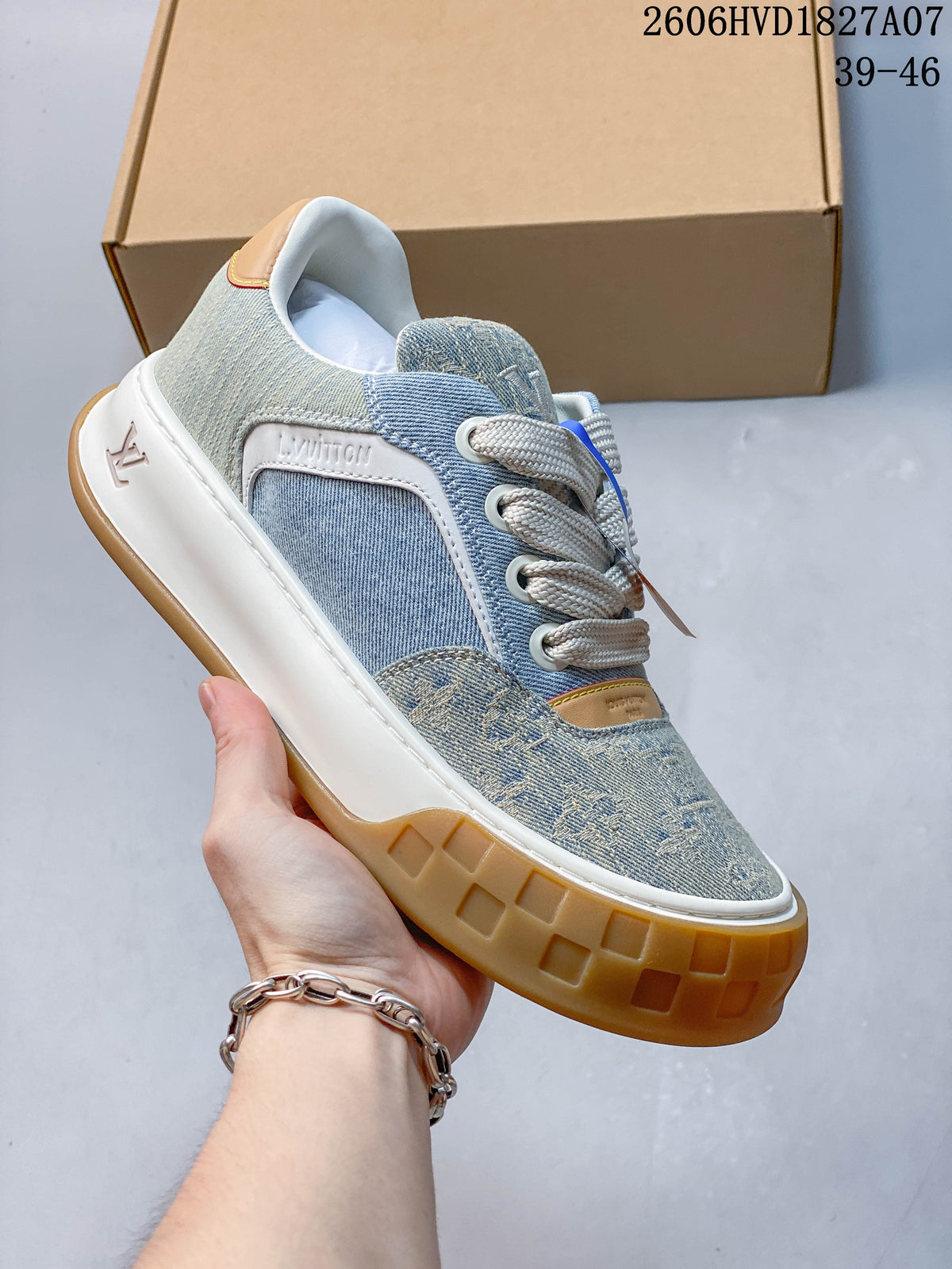 Angled side view of the blue denim-style sneaker with visible branding, cream laces, and gum-colored outsole.