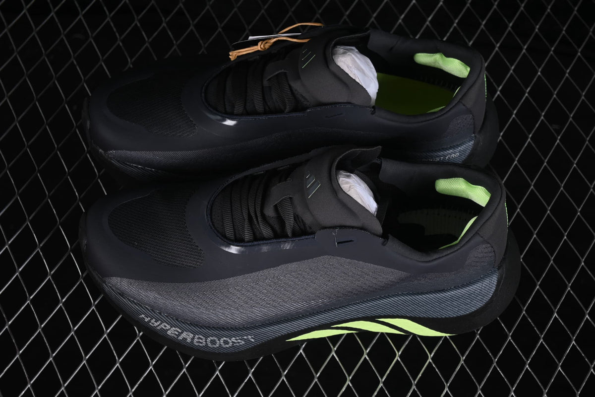 Angled top view of the pair highlighting the lace-up construction, mesh-like panels, and green accents.