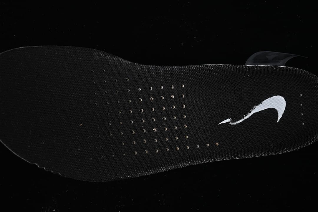 Black perforated shoe insole with a white Nike Swoosh