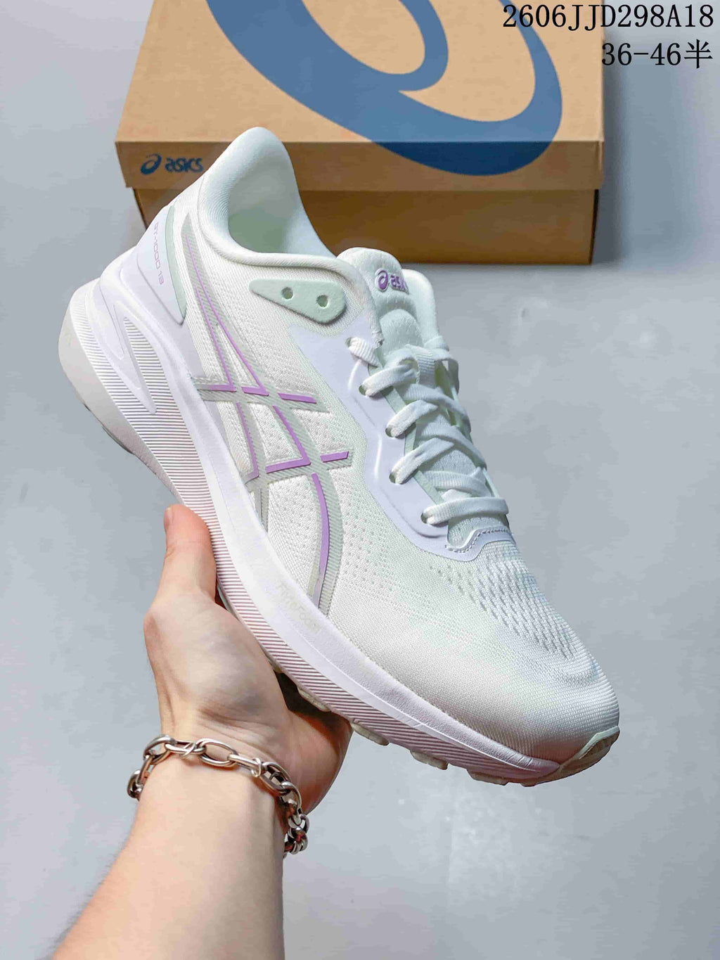 Angled side view of a white ASICS running shoe with pale purple accents