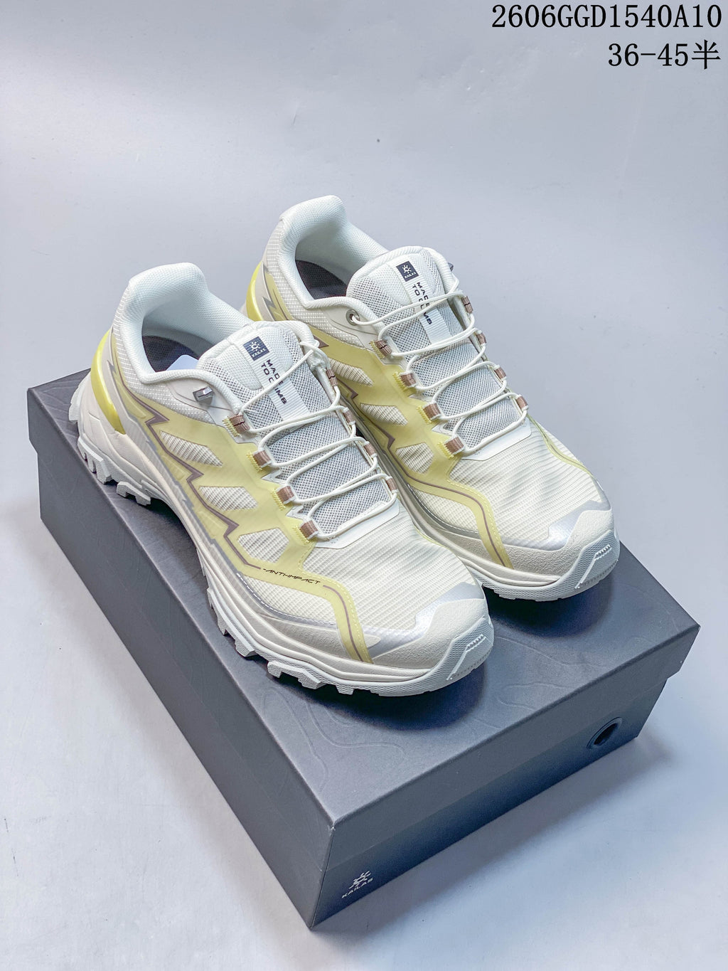 Pair of white KAILAS low-top hiking shoes with pale lime details, shown from above on a shoebox.