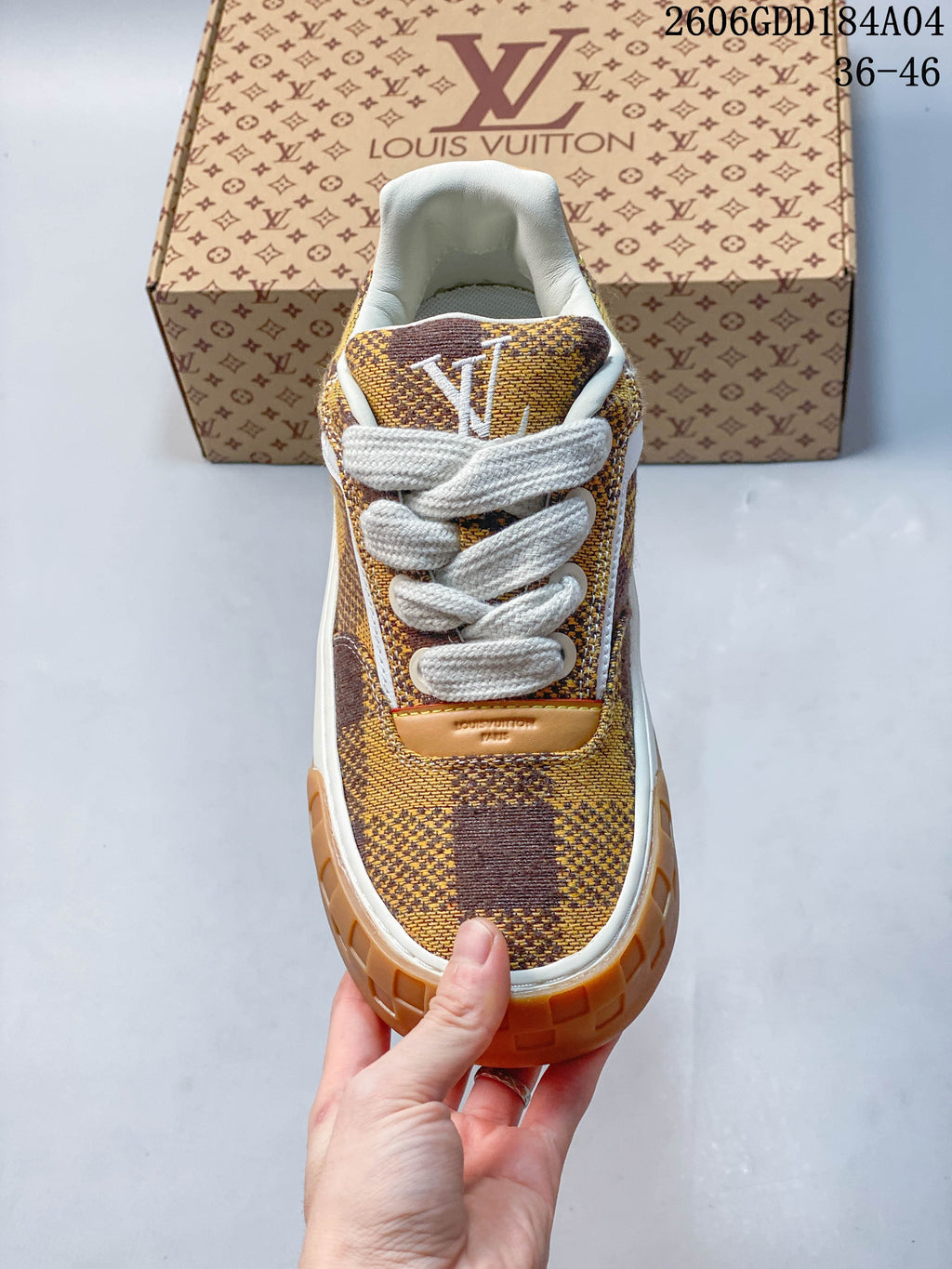 Front view of the sneaker showing white laces, check-pattern upper, and tan toe edge