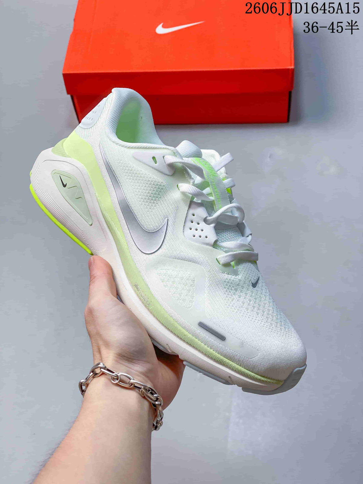 White Nike Air Structure 26 running shoe with pale lime accents, shown beside an orange shoe box.