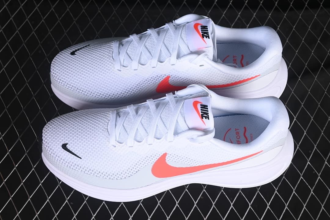 Pair of white Nike Revolution 8 shoes with coral-colored Swooshes
