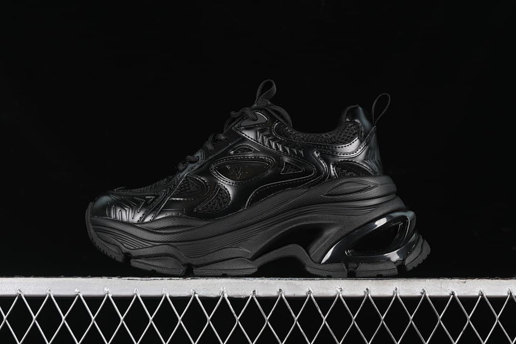 Side view of a black G24X9833 sneaker with a chunky platform-style sole.