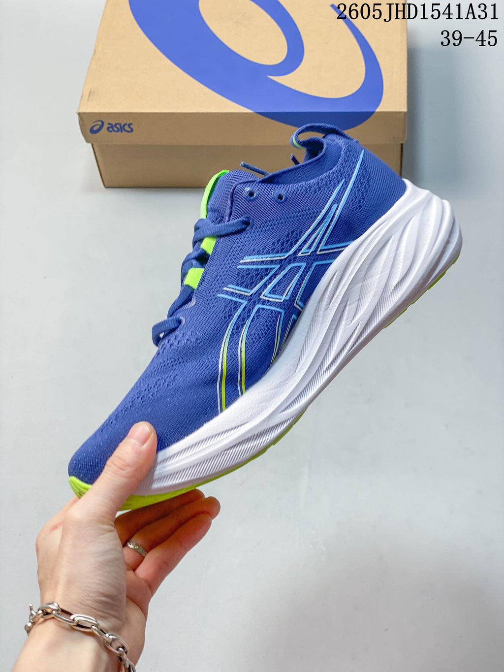 Side view of a blue ASICS running shoe with lime detailing and a white midsole