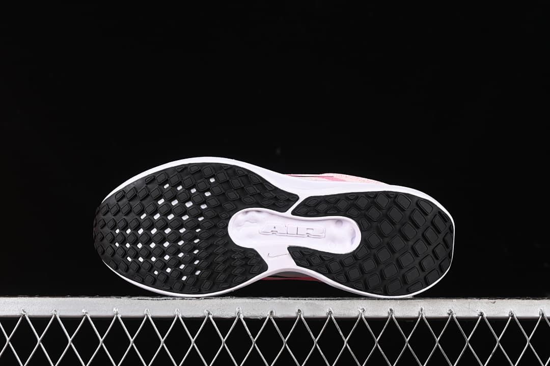 Underside view of the shoes showing the black patterned outsole and light midfoot section.