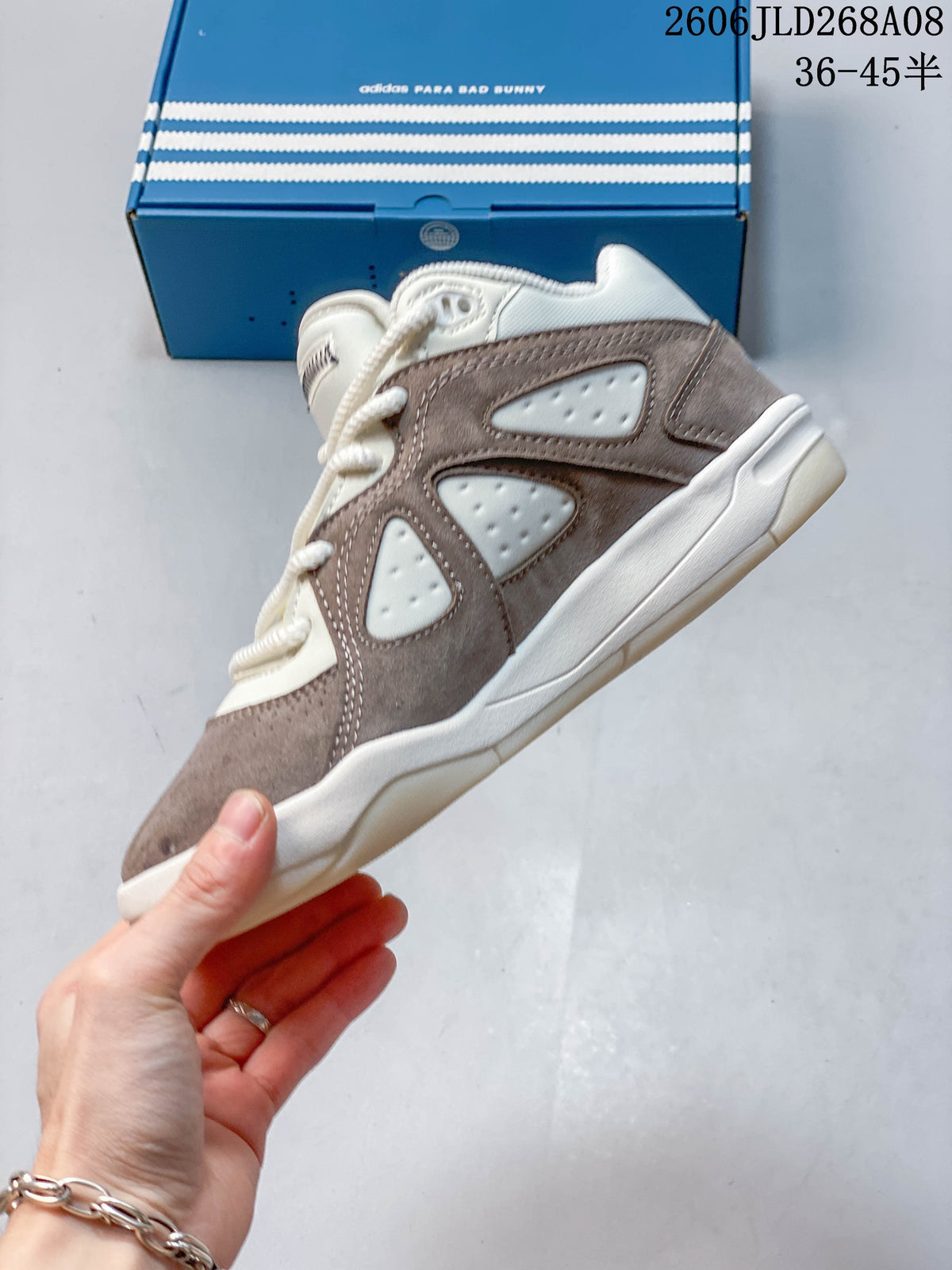 Side view of the taupe and cream sneaker with perforated panels