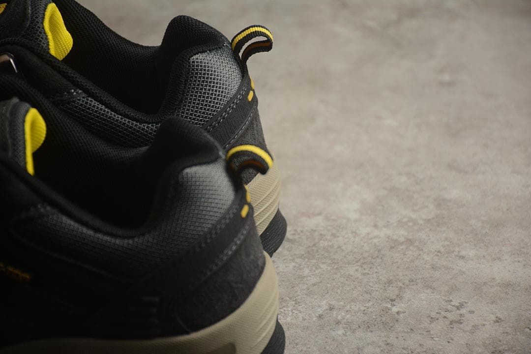 Close-up of the black padded collars and yellow-accented heel pull tabs.