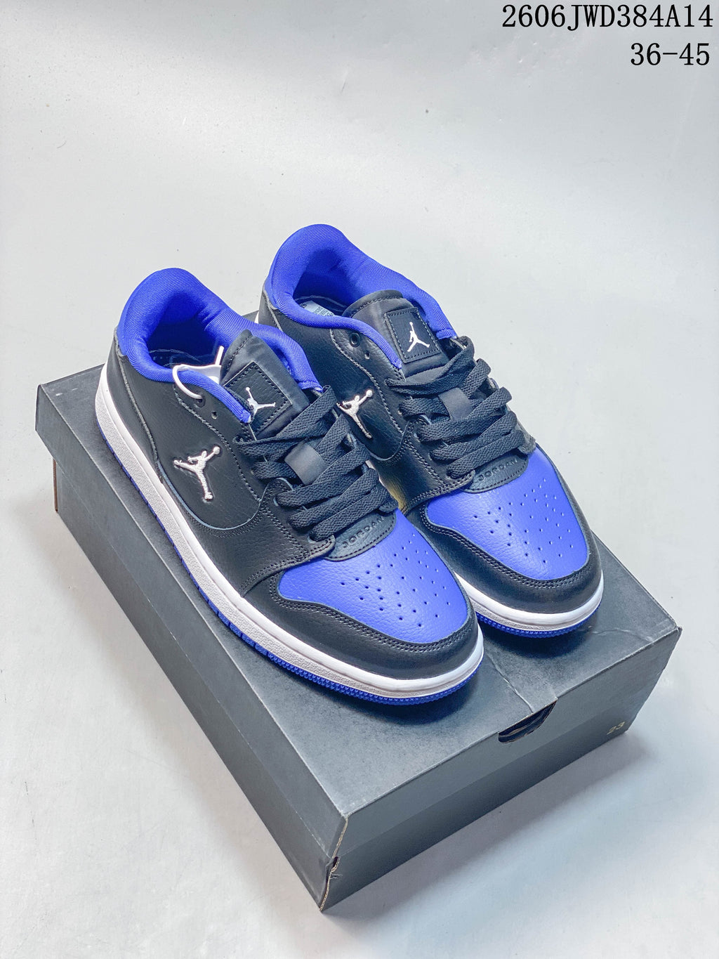 Pair of dark gray, blue, and white Jordan Court Connect low-top sneakers on a shoebox