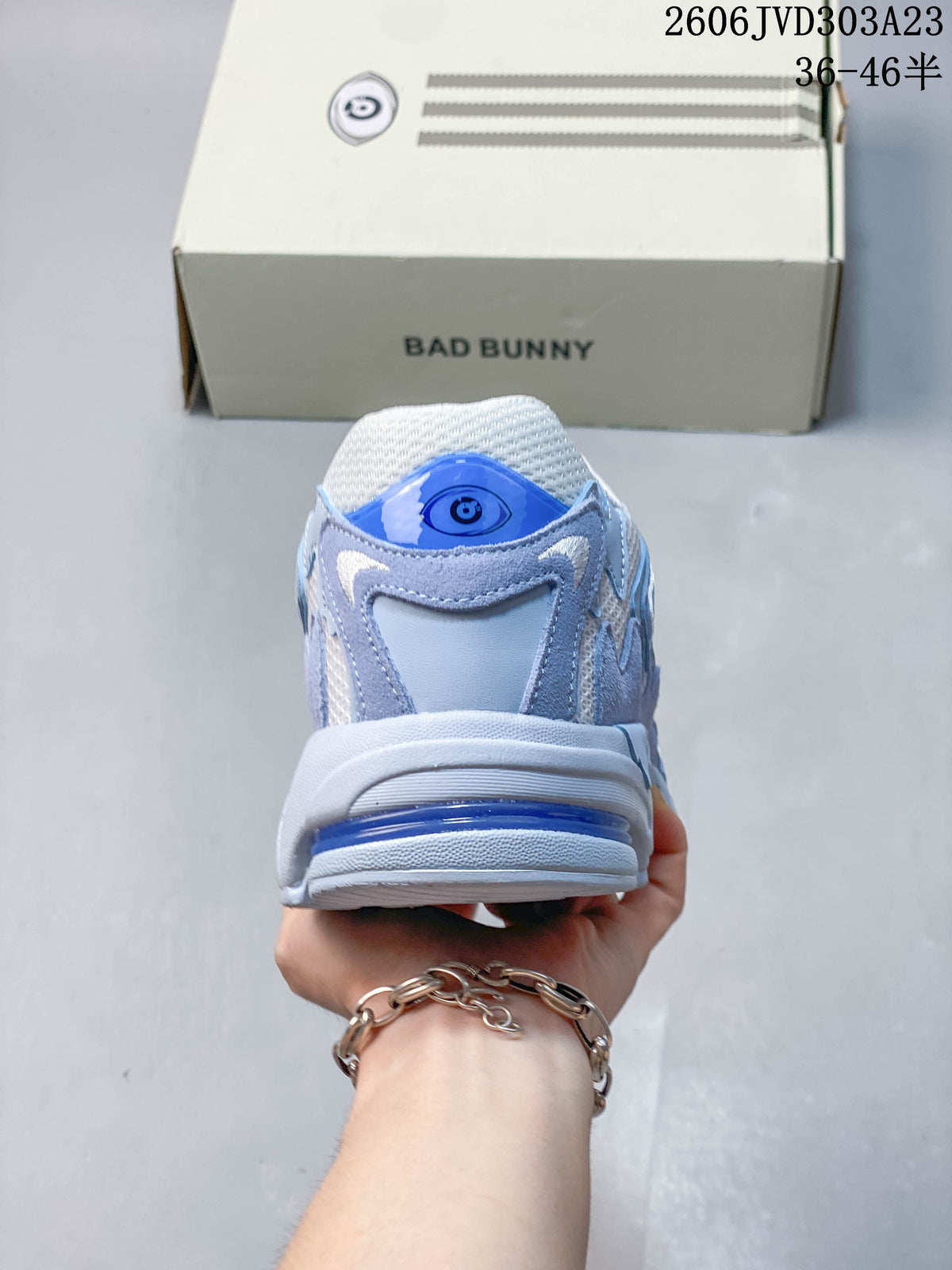 Rear view of the sneaker with blue heel detailing and a Bad Bunny box behind it