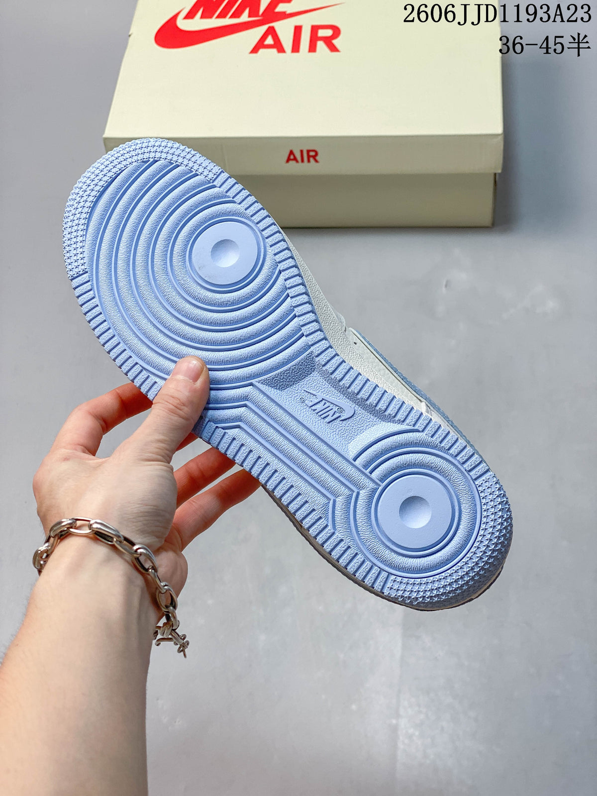 Underside of a Nike Air Force 1 sneaker showing a pale blue patterned outsole