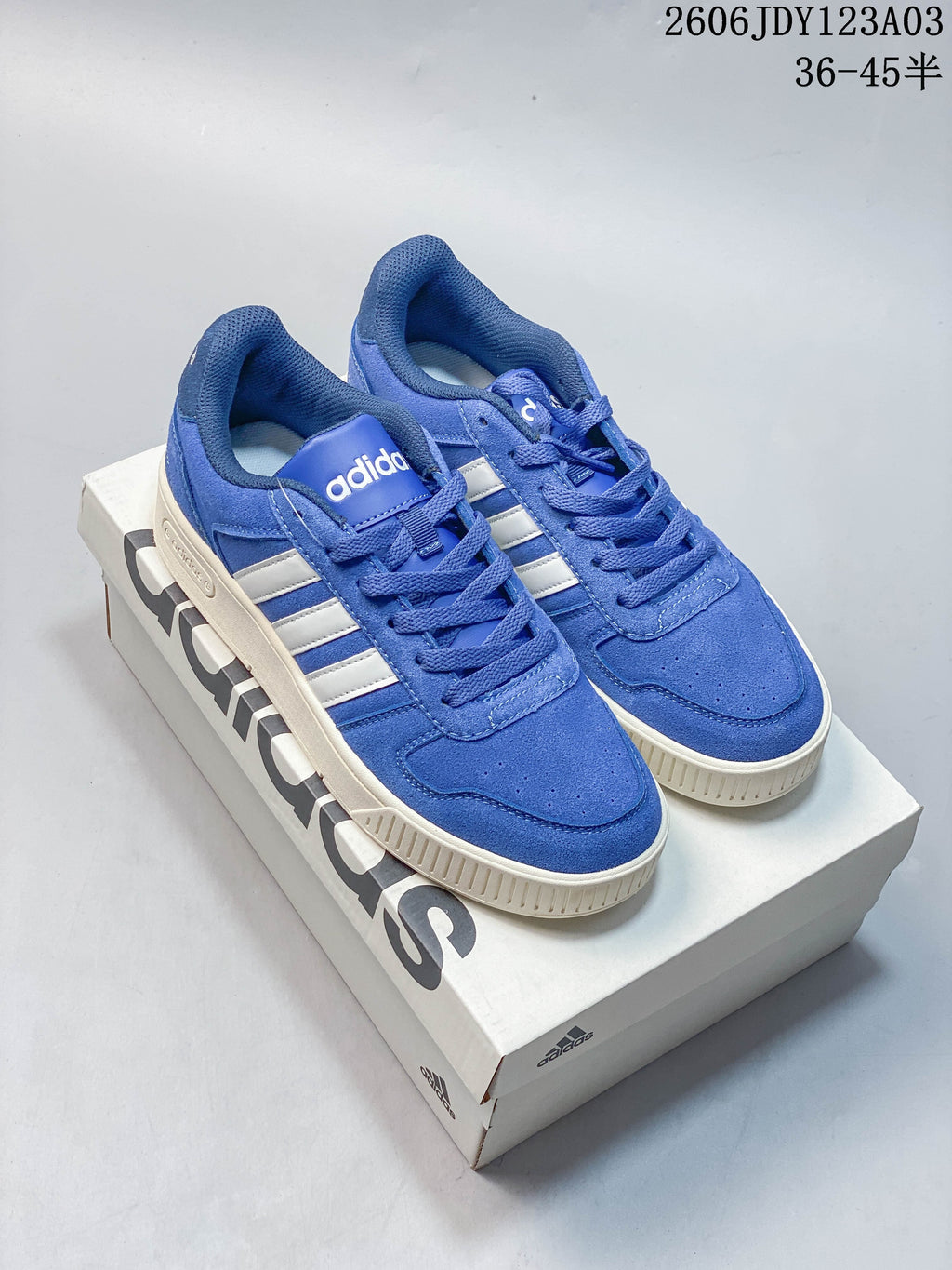 Blue and red Adidas low-top sneakers shown together on a shoe box.