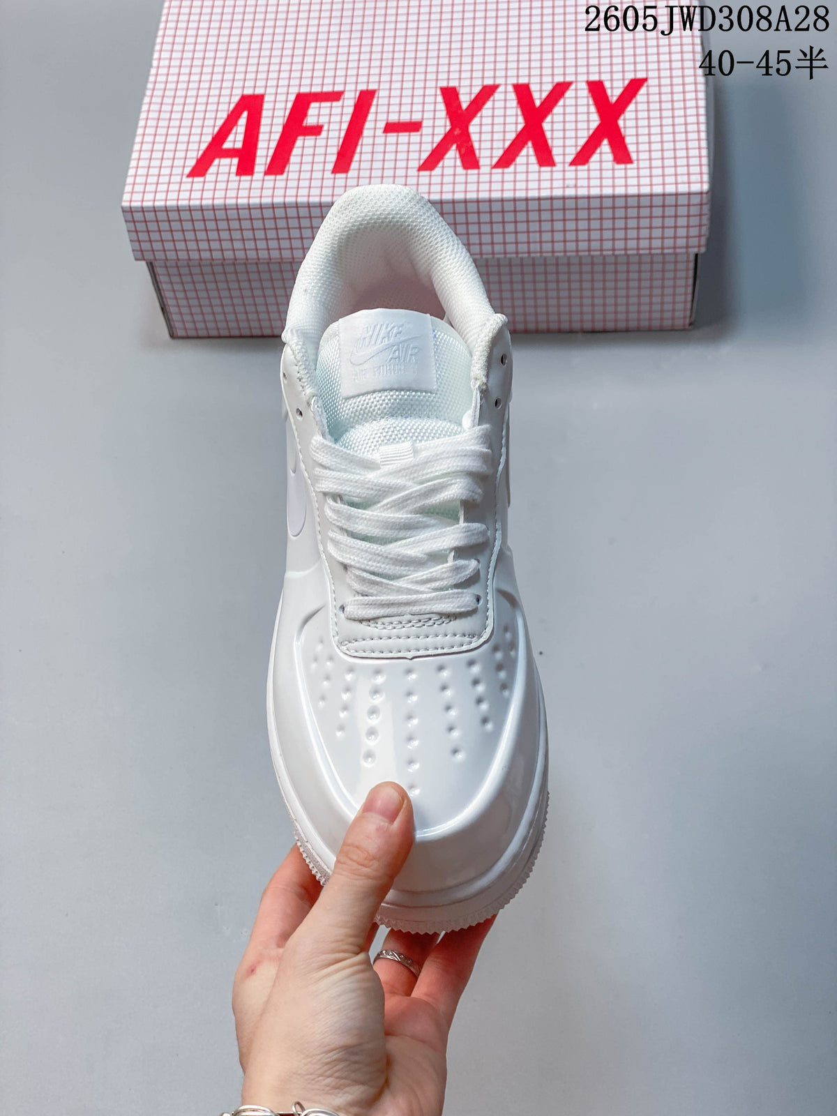 Top view of a white lace-up sneaker with perforations across the toe