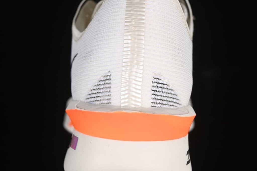Rear view showing the heel and bright orange midsole accent.