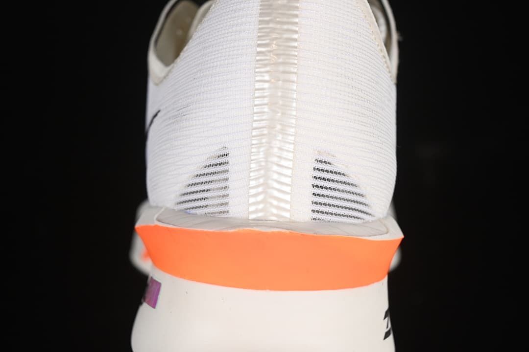 Rear view showing the heel and bright orange midsole accent.