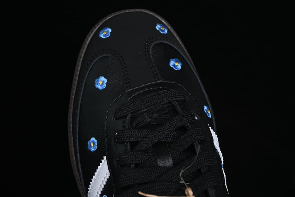 Top view of the black toe with blue floral details and black laces