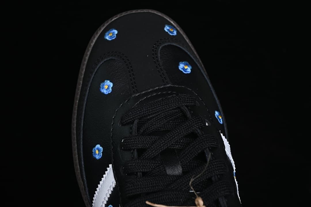 Top view of the black toe with blue floral details and black laces