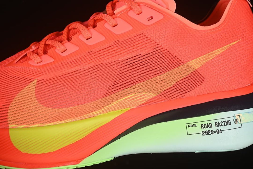 Close-up of the side swoosh, coral upper, yellow accent and sculpted midsole.