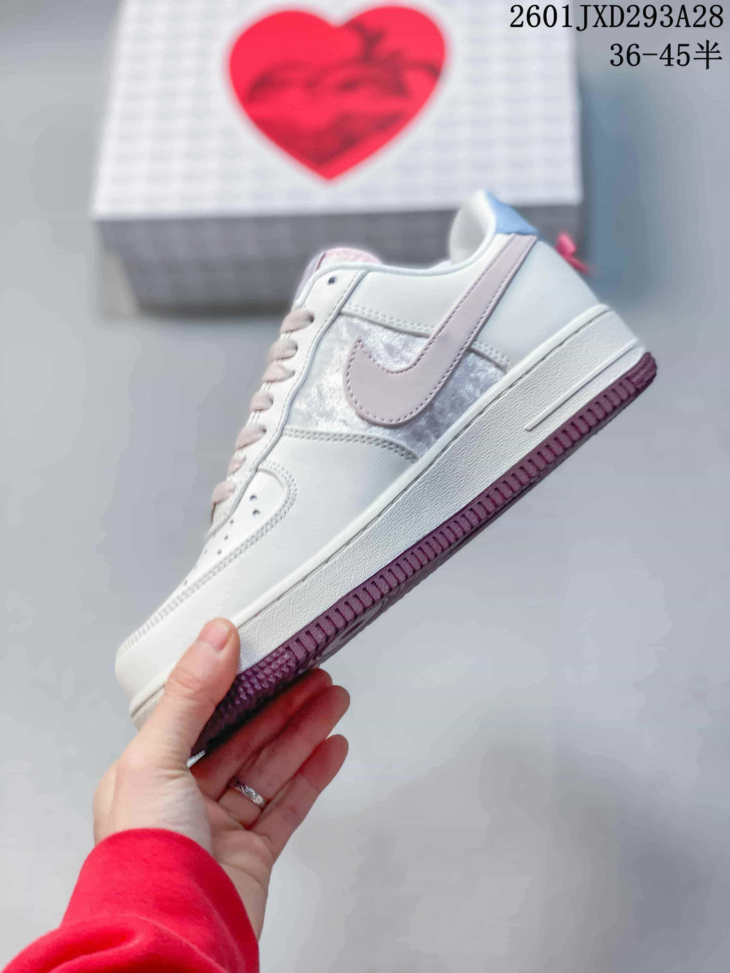 Side view of the white sneaker with pale pink side emblem and mauve outsole.