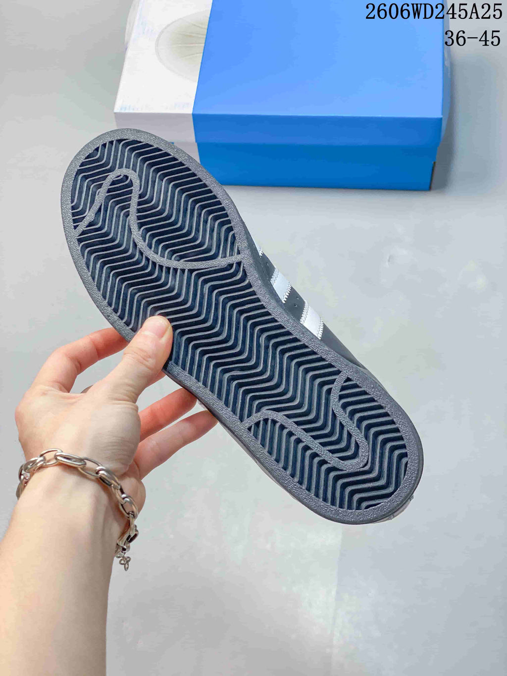 Underside of a dark gray sneaker showing a patterned outsole