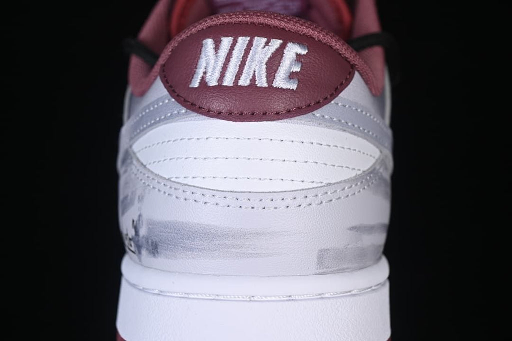 Rear close-up of white and gray sneaker panels with burgundy Nike heel tab