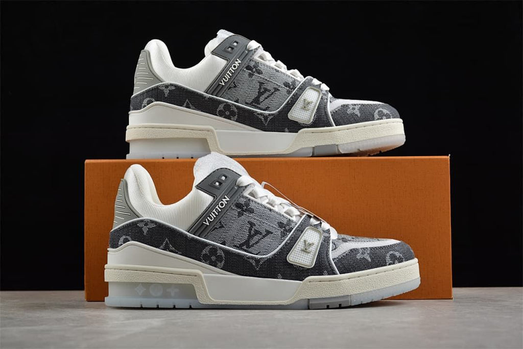 Pair of gray patterned sneakers displayed on an orange box.