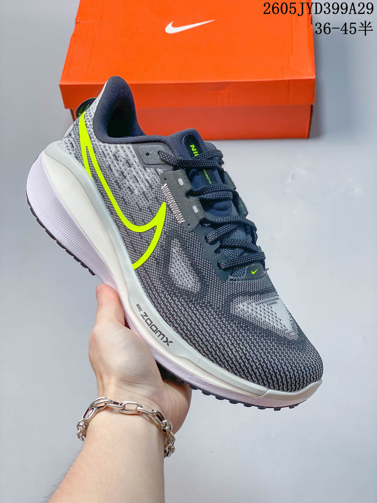 Gray Nike Air Zoom Vomero 17 running shoe with neon yellow accents.