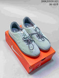 Pair of pale blue-gray Nike Astrograbber Leather sneakers displayed on an orange shoebox